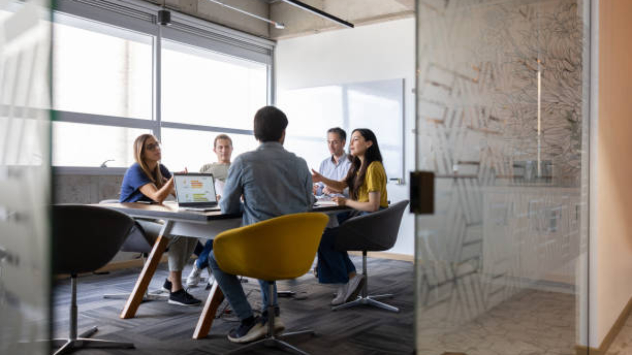 Group of Latin American business people talking in a meeting at the office
