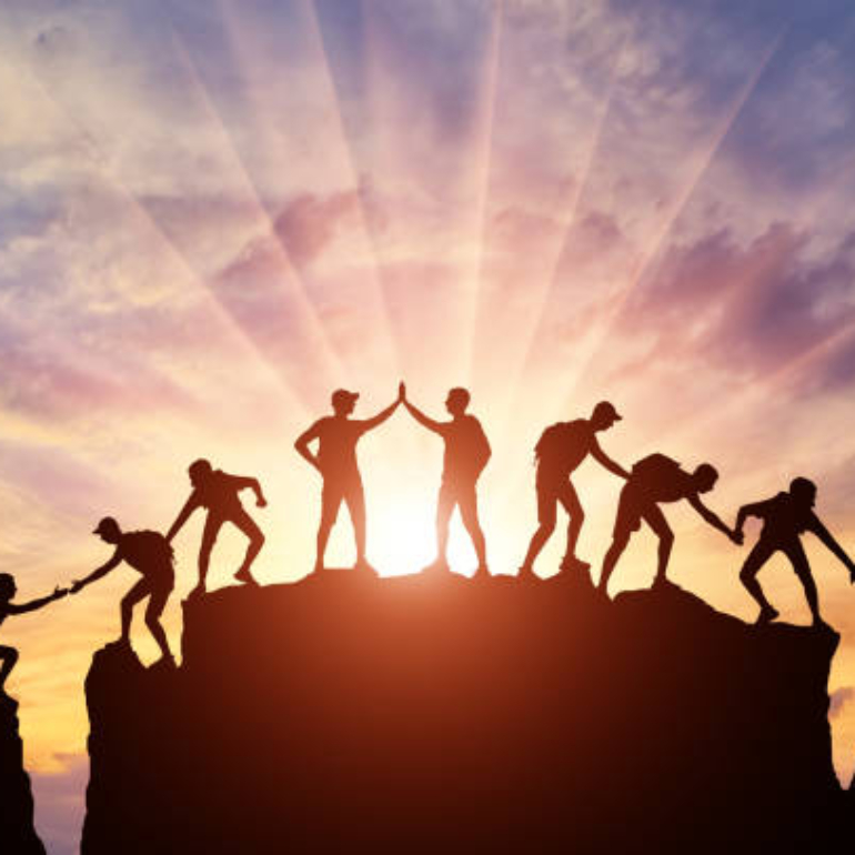 Silhouette of climbers who climbed to the top of the mountain thanks to mutual assistance and teamwork. Conceptual scene of a team of alpinists