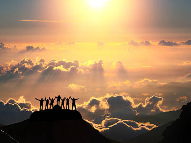 A group of people standing on a hill over the beautiful cloudscape.
